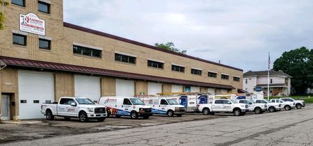 A row of trucks are parked in front of a building.