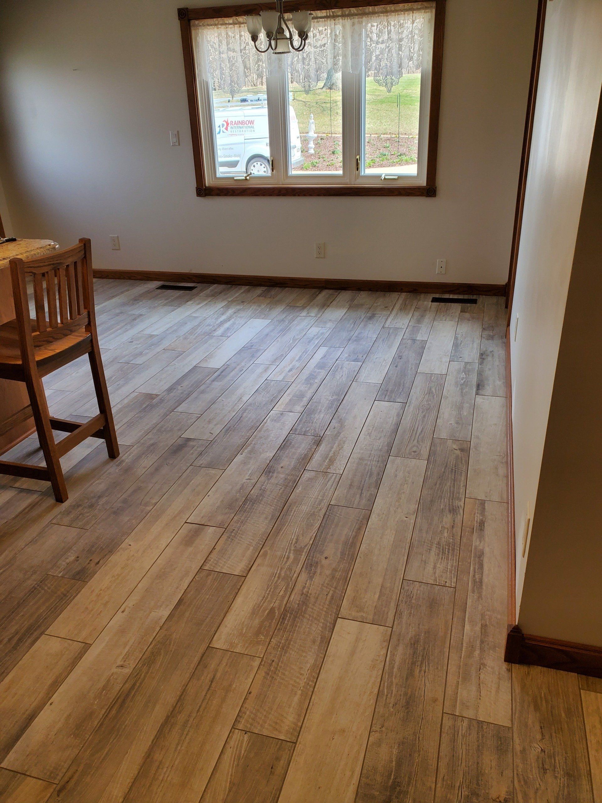 A living room with a wooden floor and a window.