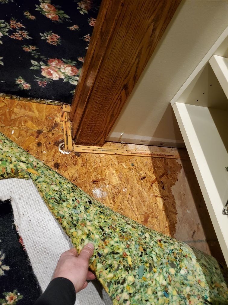 A person is holding a piece of foam next to a door.