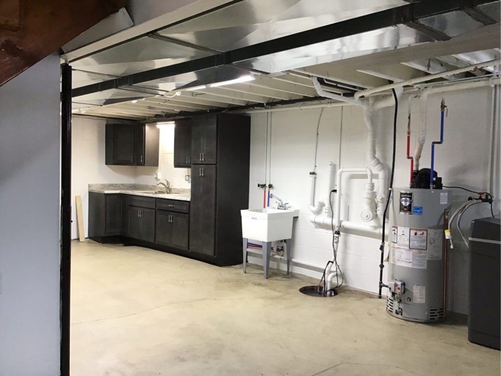 A basement with a sink and a water heater.