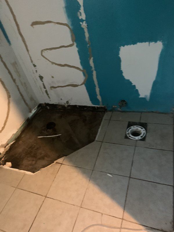 A bathroom with a tiled floor and a blue wall.