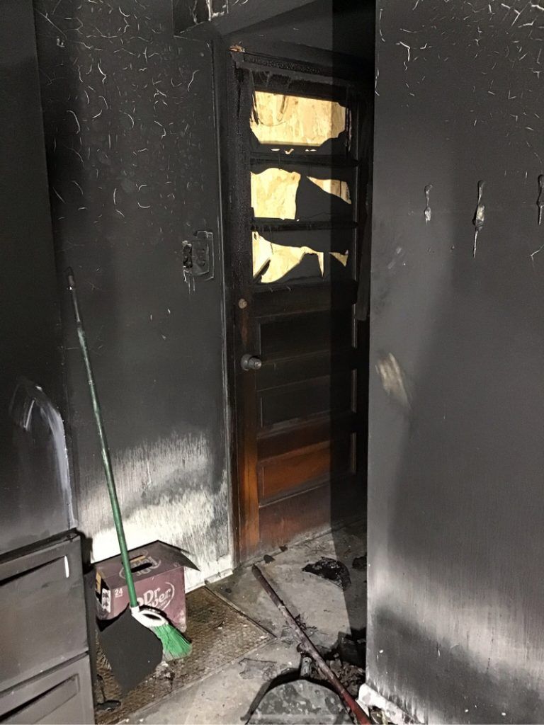 A room with a door and a broom in it.