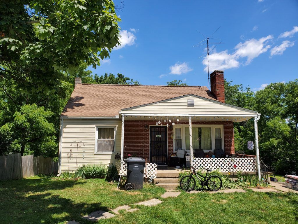 A small house with a bicycle parked in front of it.