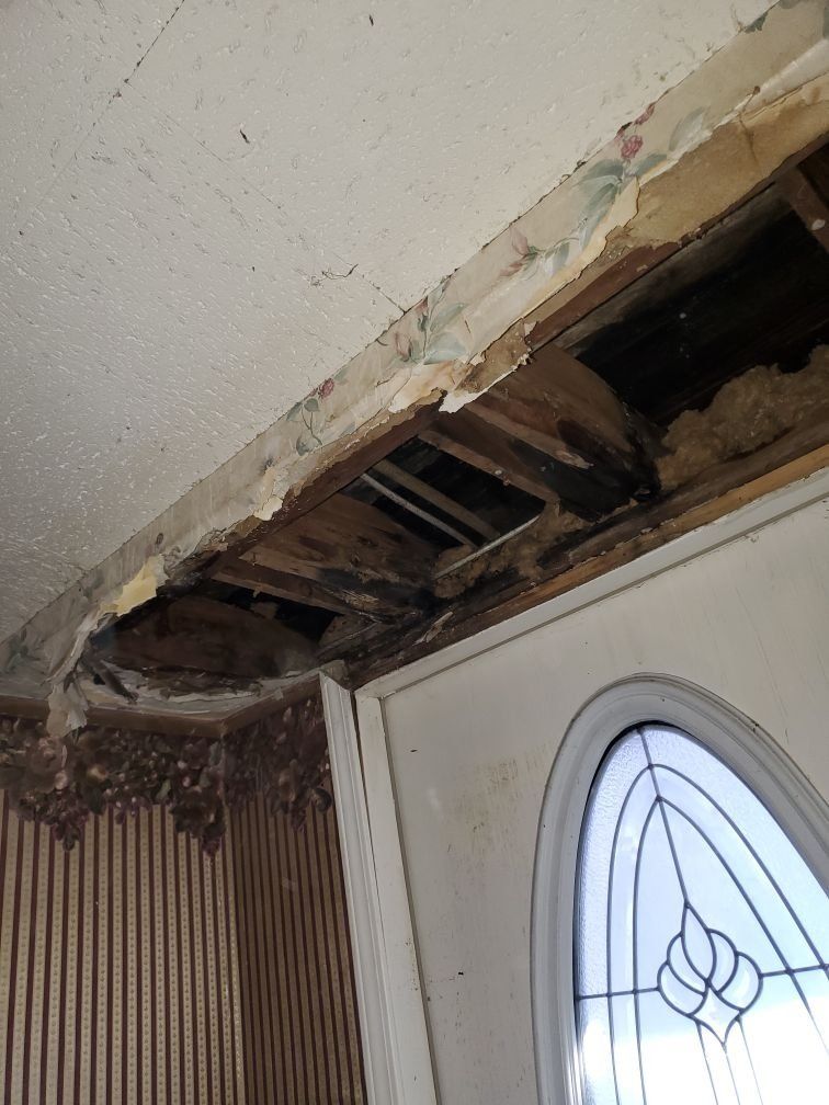 A water damaged ceiling with a hole in it.