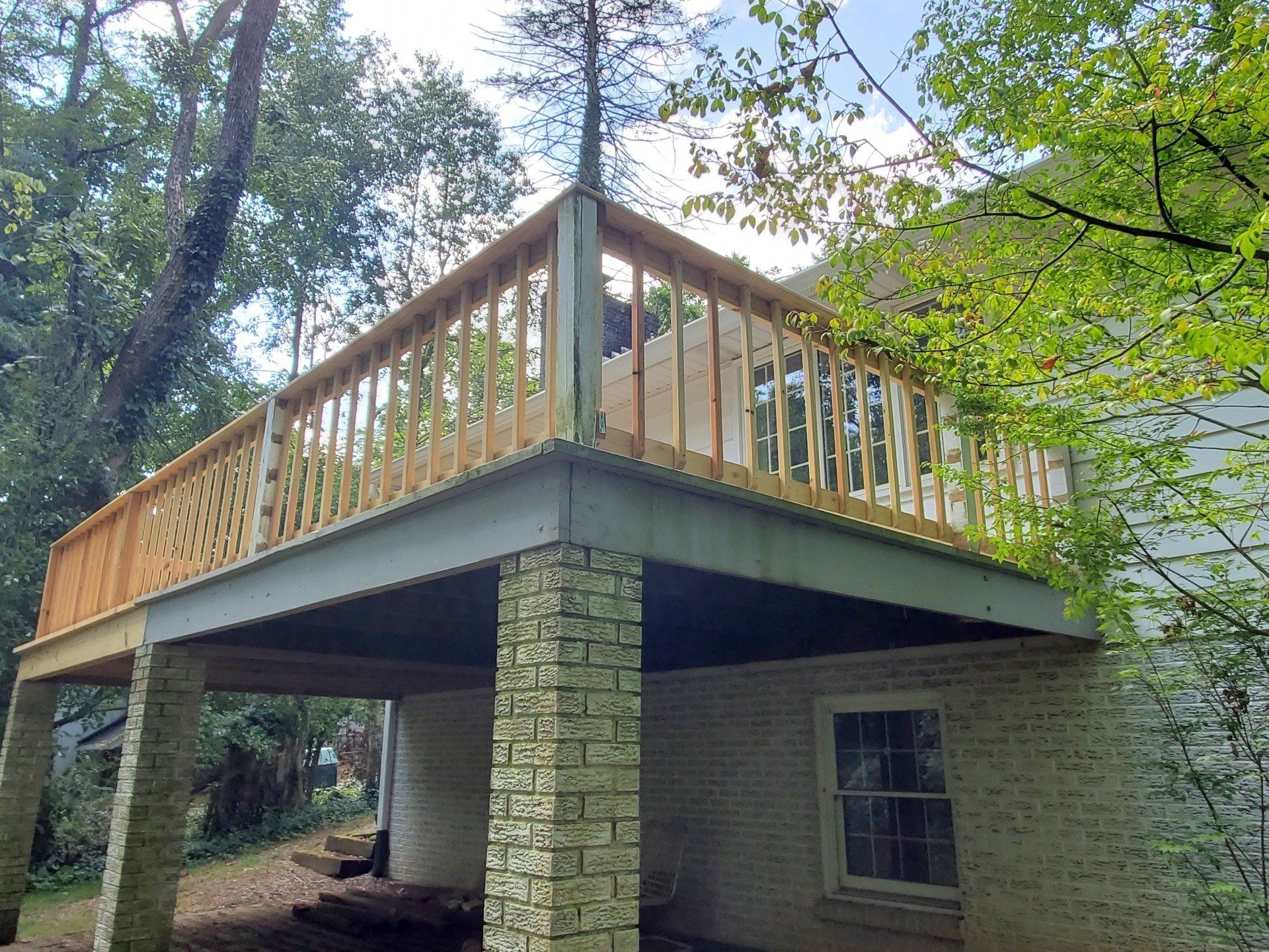 A wooden deck is being built on top of a brick house.