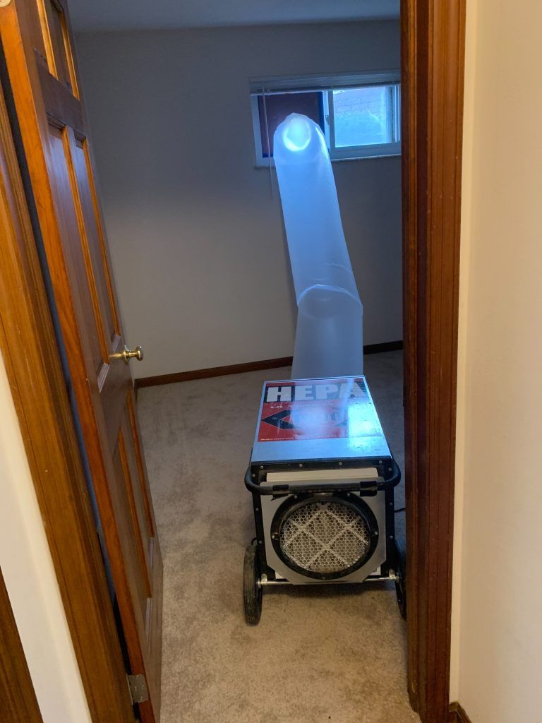 An industrial machine is sitting in a hallway next to a door.