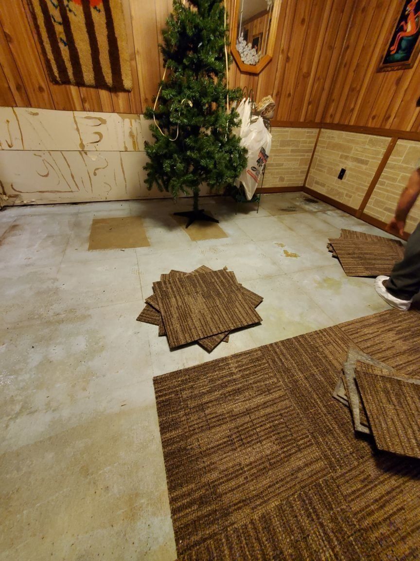 A christmas tree is sitting on top of a carpeted floor in a room.