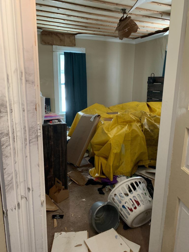 A room with a lot of junk in it and a ceiling fan.