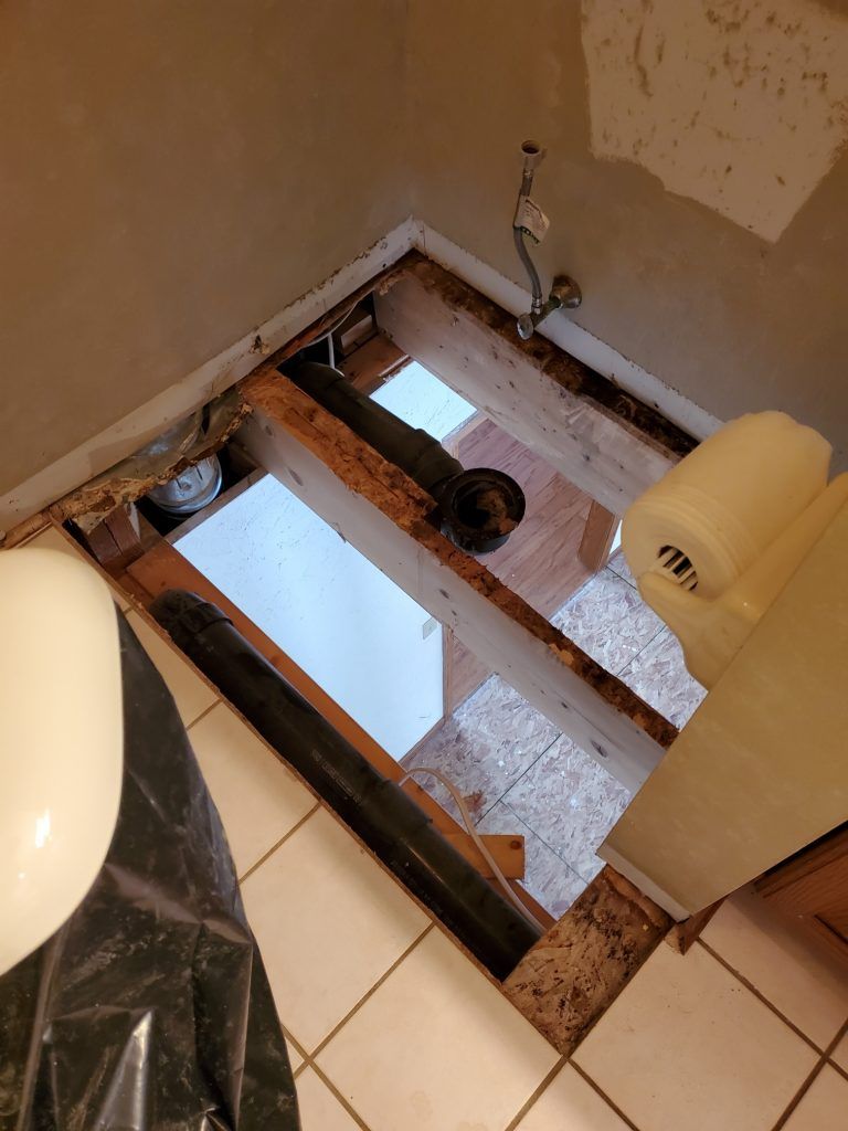 Floor ripped out in bathroom to view the lower level.