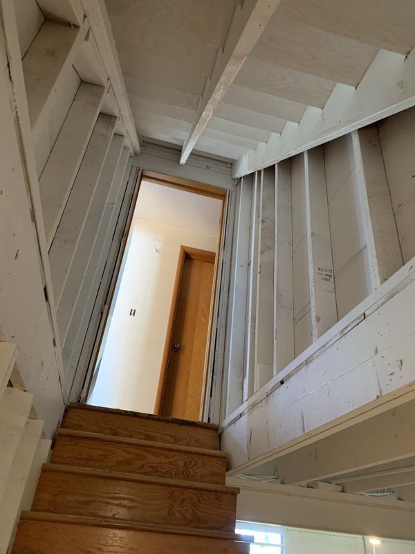 A wooden staircase leading up to a door of a house