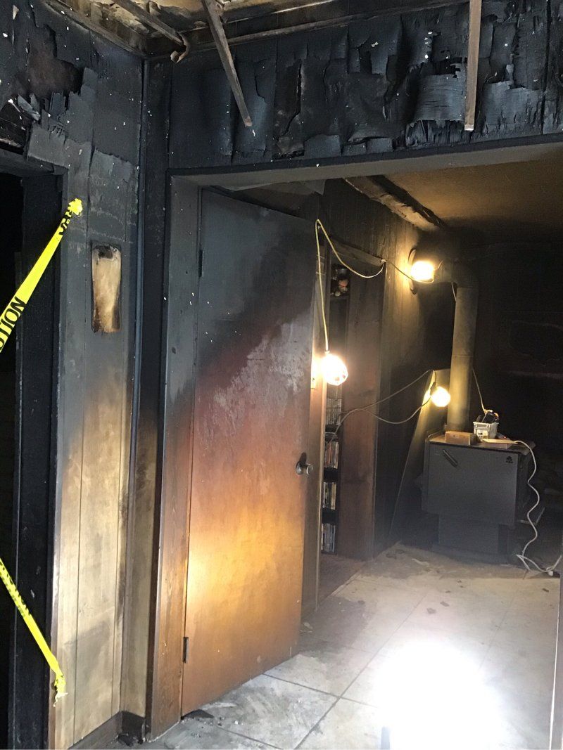 A dark room with a yellow caution tape hanging from the ceiling.