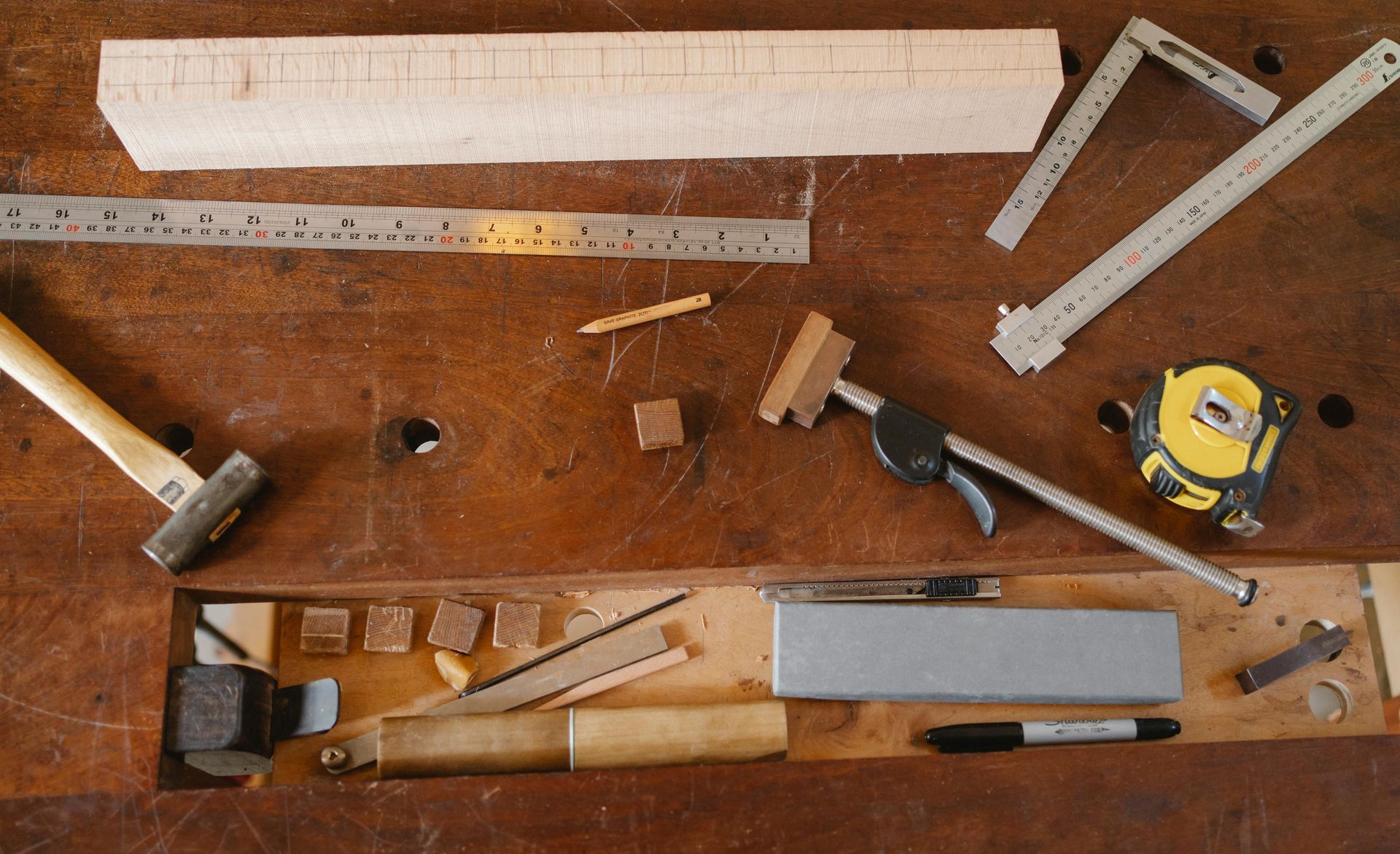 A wooden house with tools on a wooden table.