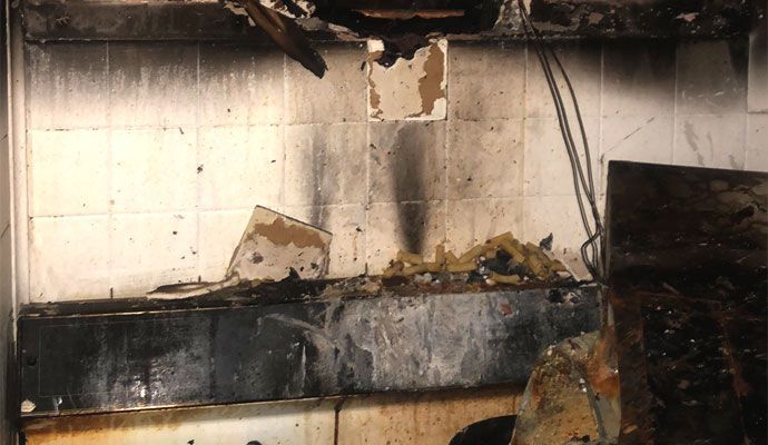 A kitchen with which has been damaged by fire. 