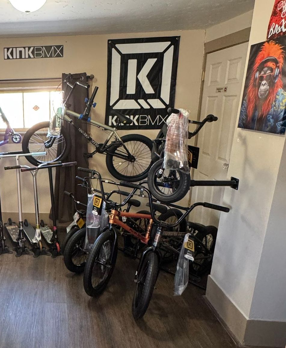 A room filled with bikes and scooters and a sign that says kink-tax