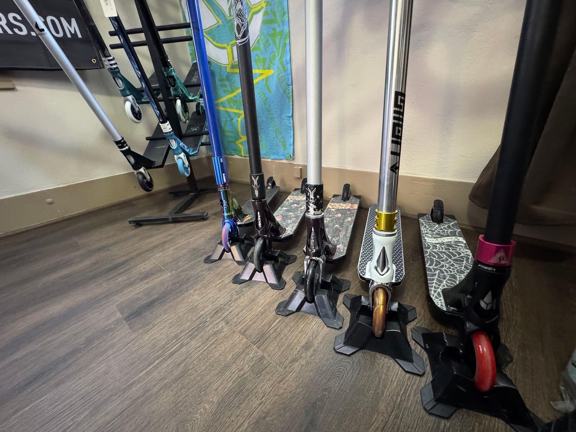 A bunch of scooters are sitting on a wooden floor.