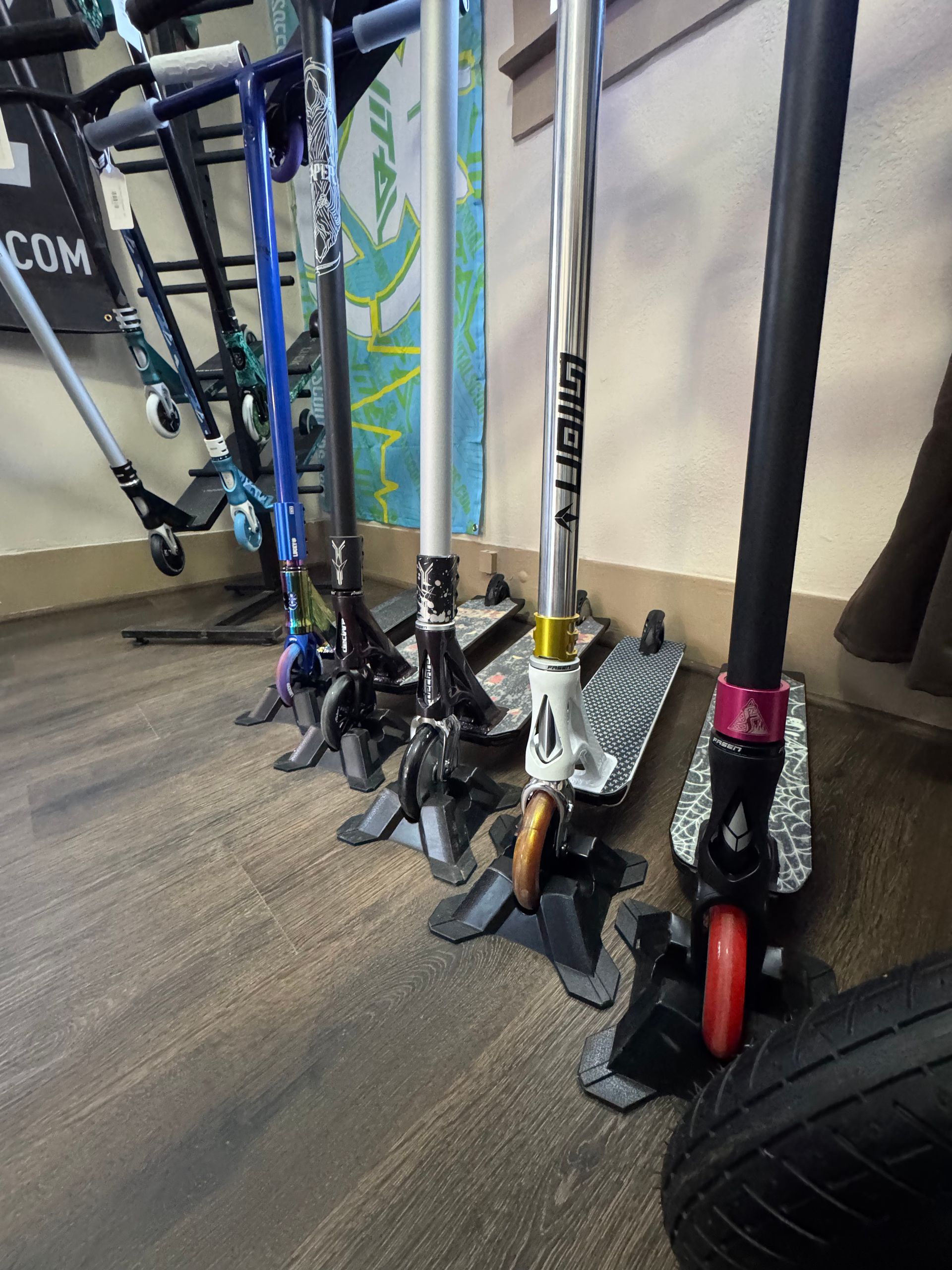 A row of scooters are lined up on a wooden floor