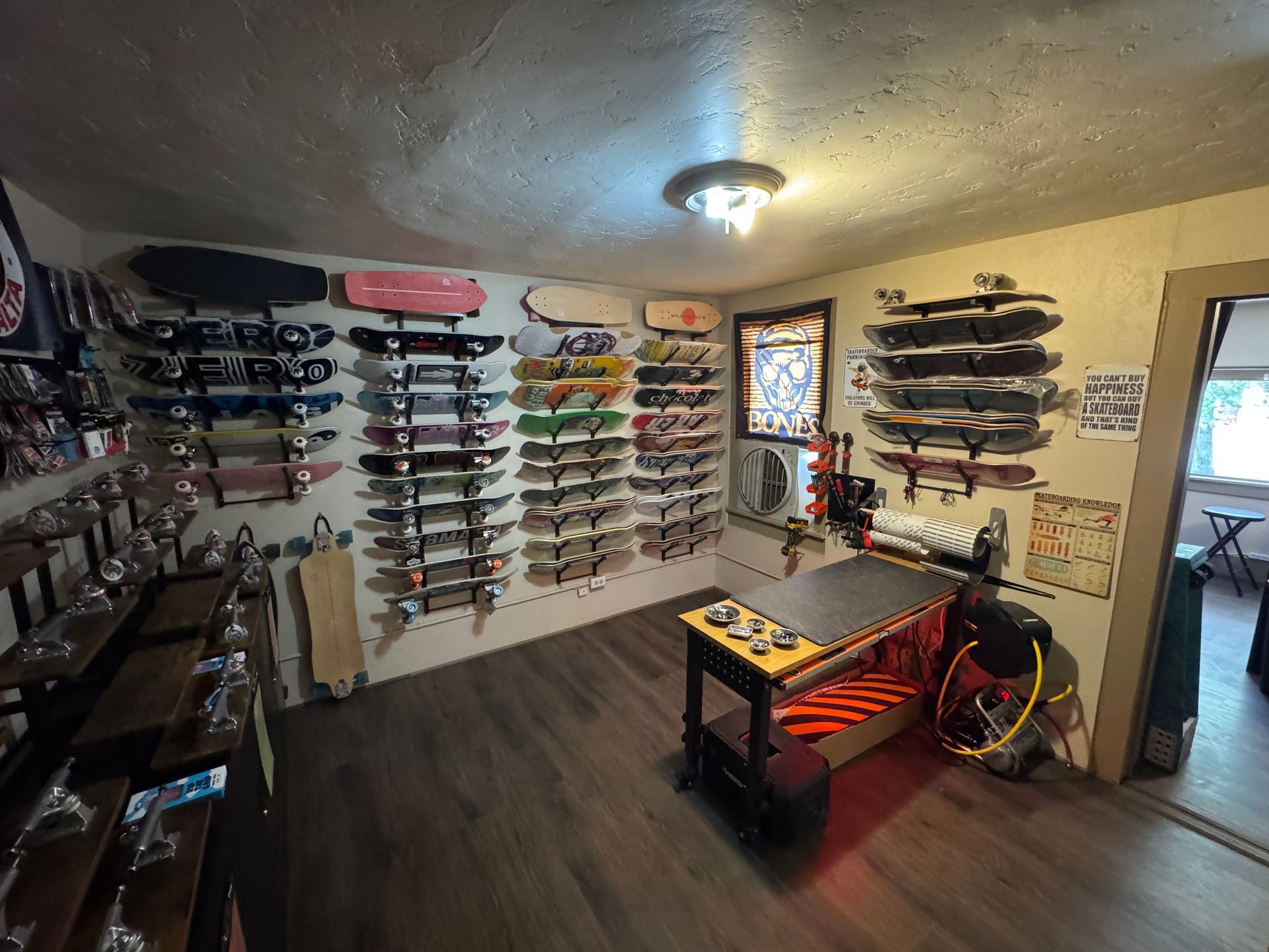 A room filled with lots of skateboards on the wall.