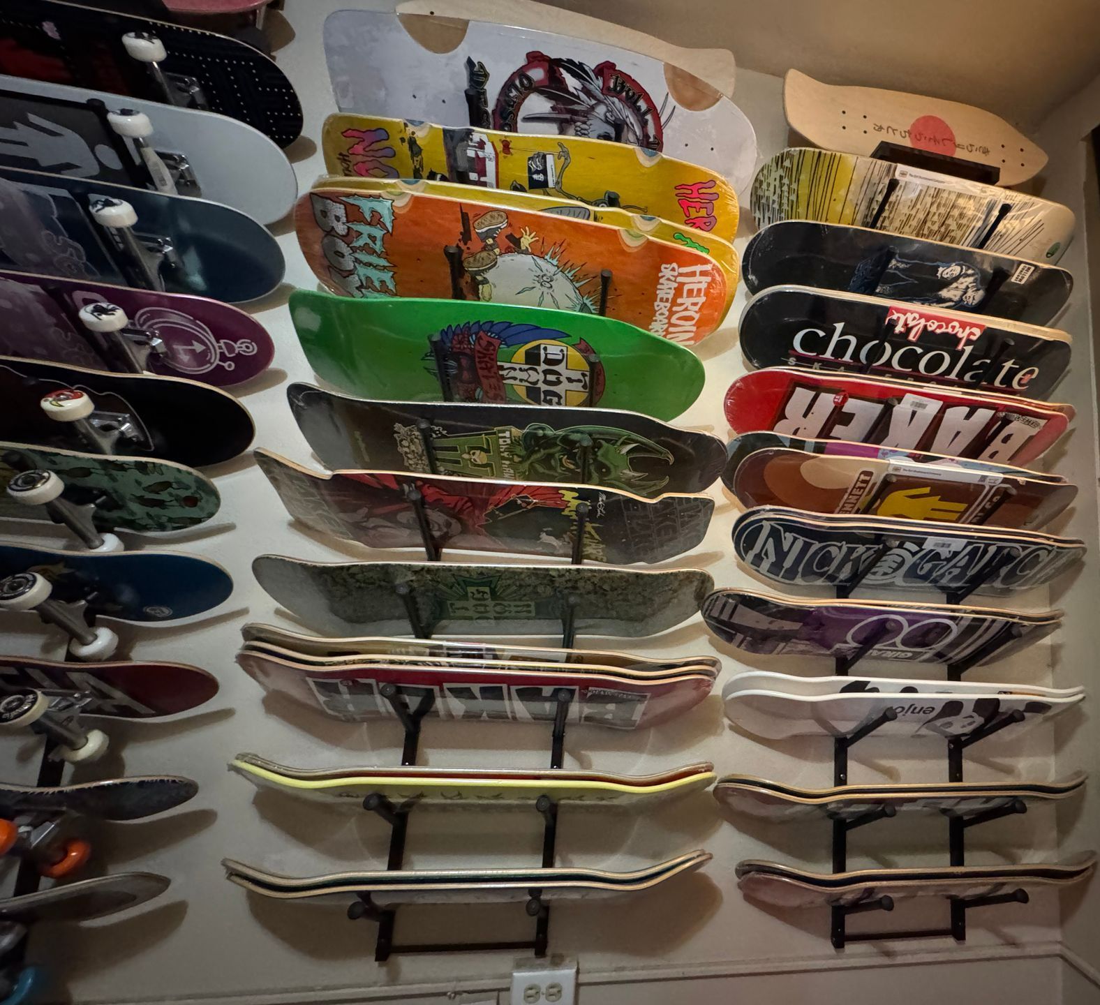 A wall full of skateboards including one that says chocolate