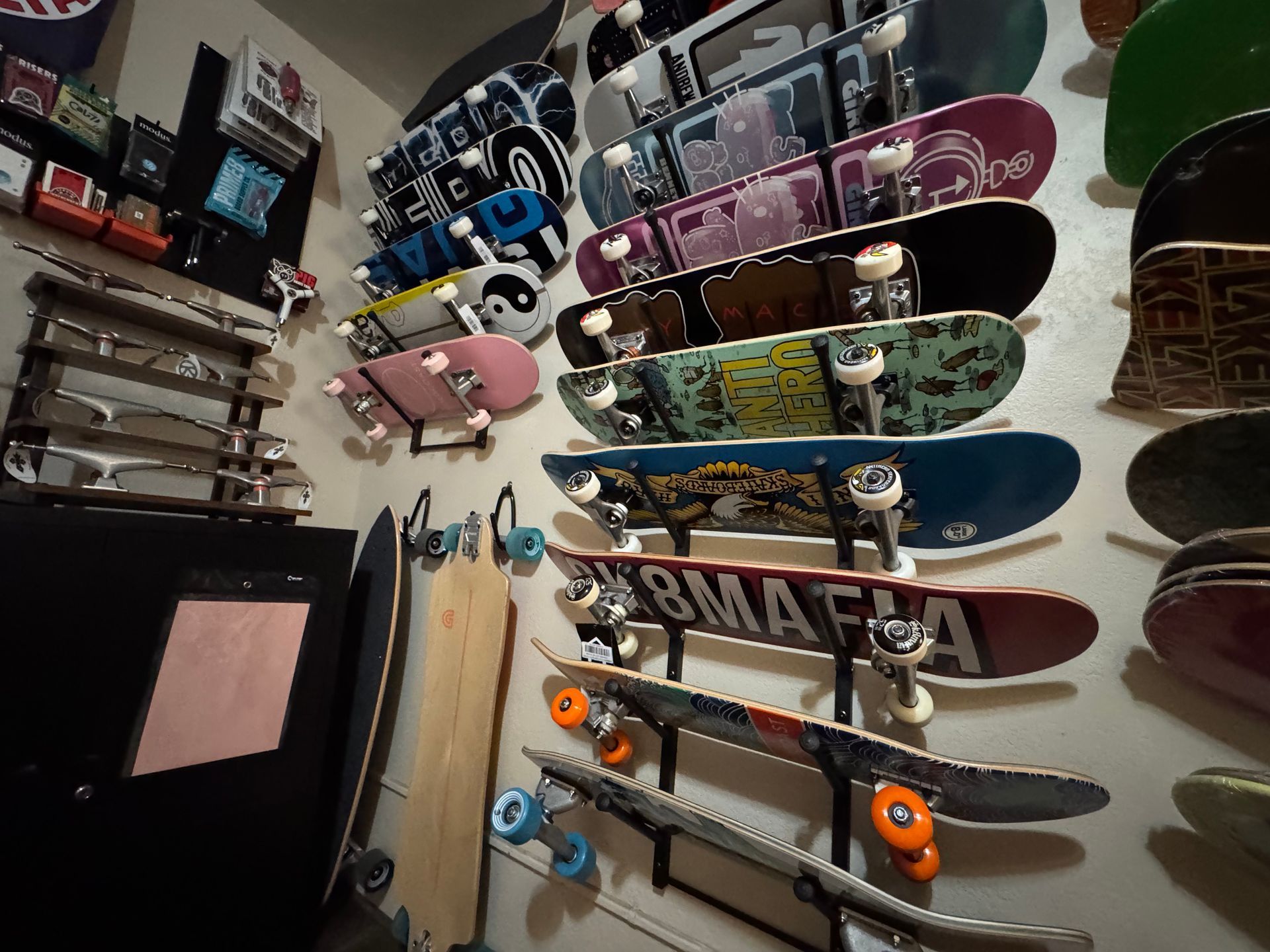 A bunch of skateboards hanging on a wall with one that says mafia