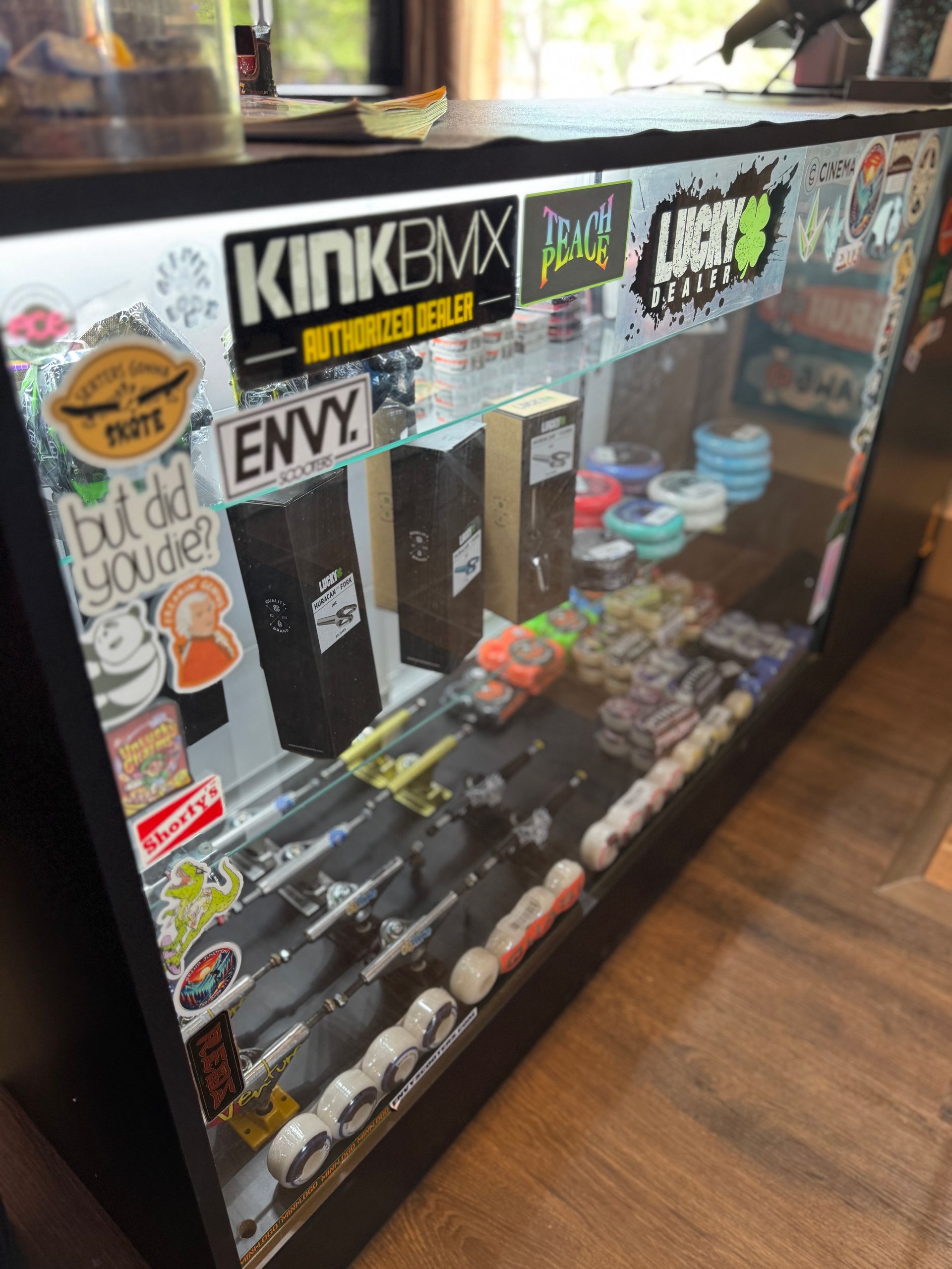 A display case with stickers on it including kinkbmx and envy