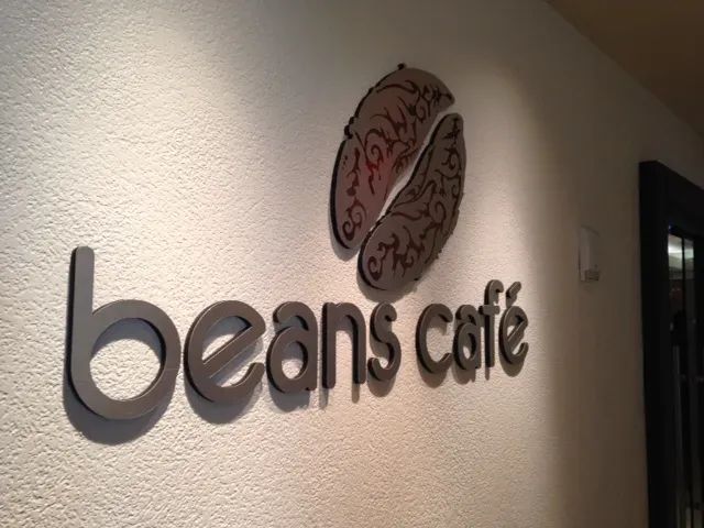 A sign on a wall that says beans cafe
