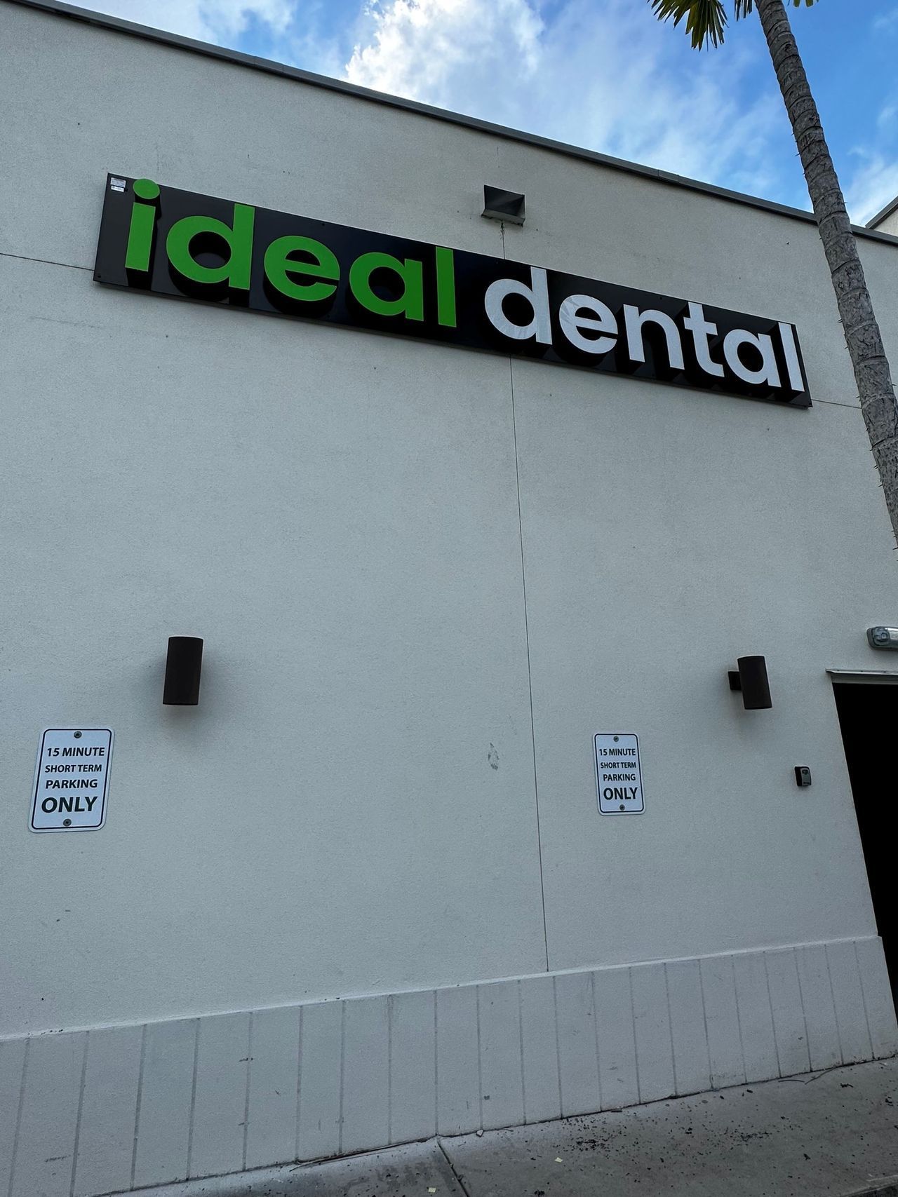 A white building with a sign that says ideal dental