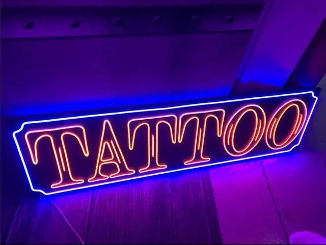 A neon sign that says tattoo on it