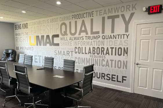 A conference room with a wall that says quality on it
