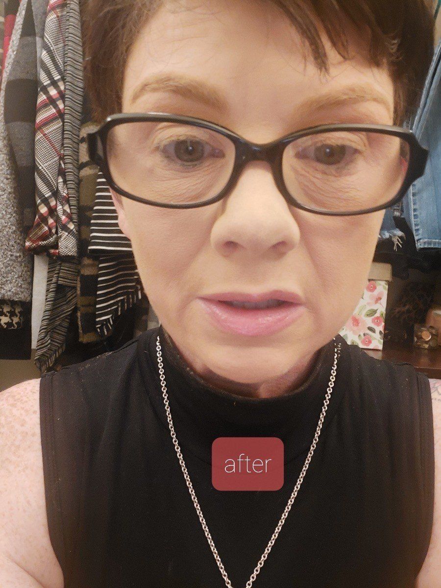 A black and white photo of a woman wearing glasses and a necklace.
