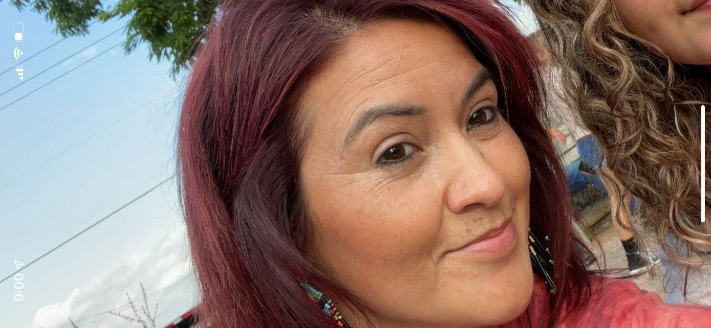 A woman is smiling in a black and white photo.