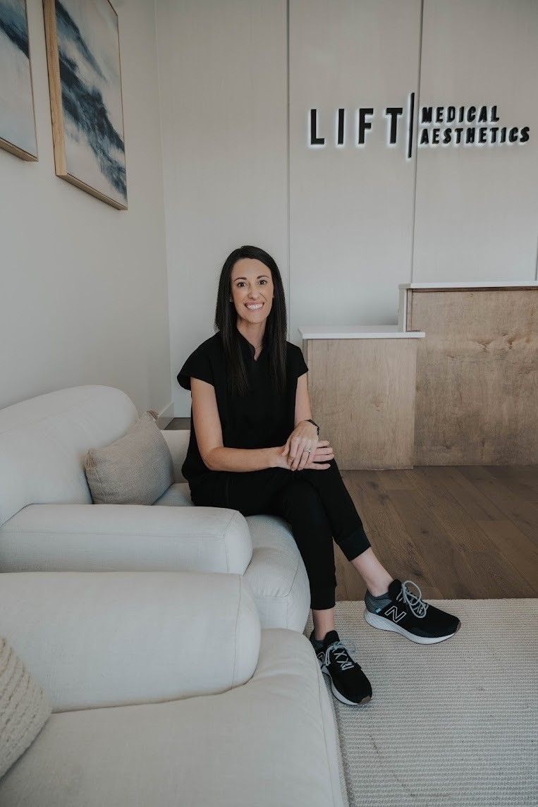 A woman is sitting on a couch in a waiting room.