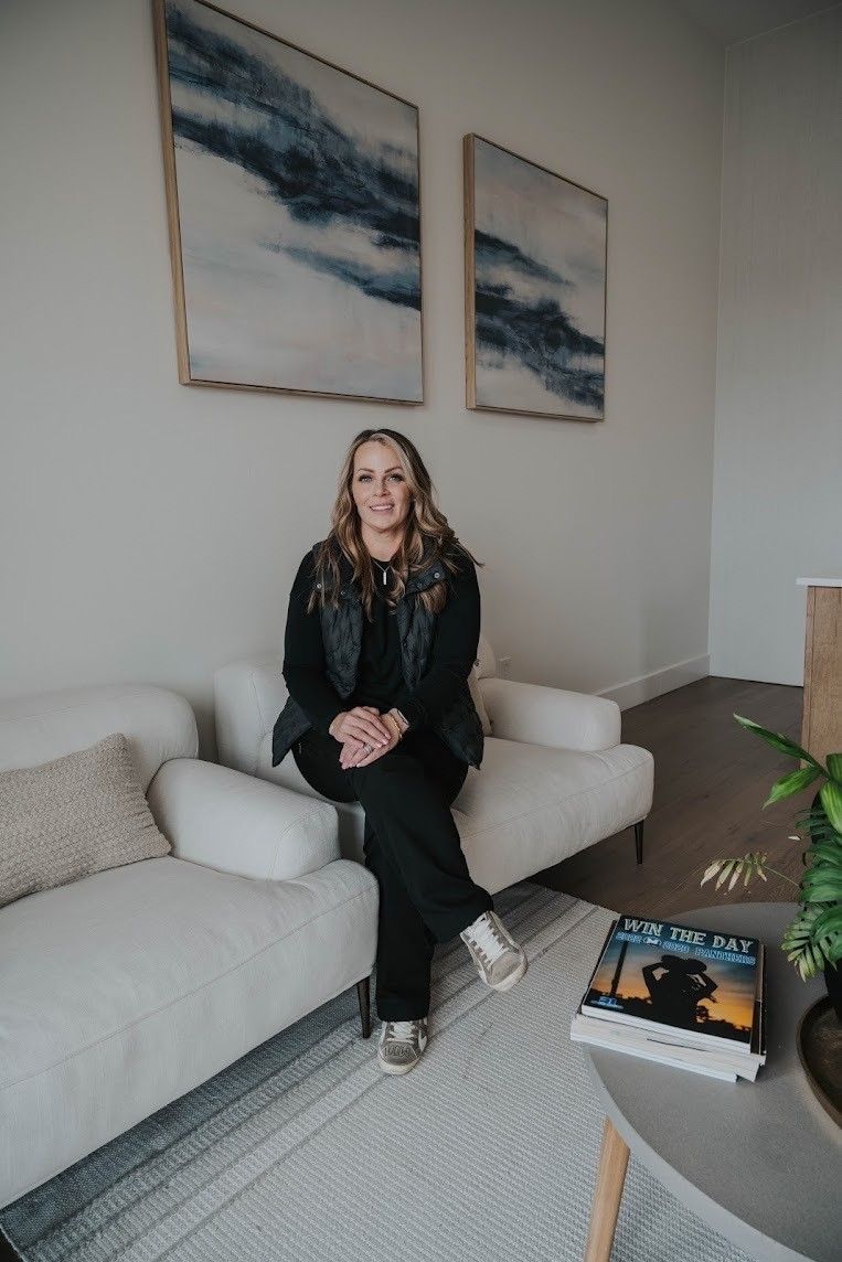 A woman is sitting on a couch in a living room.