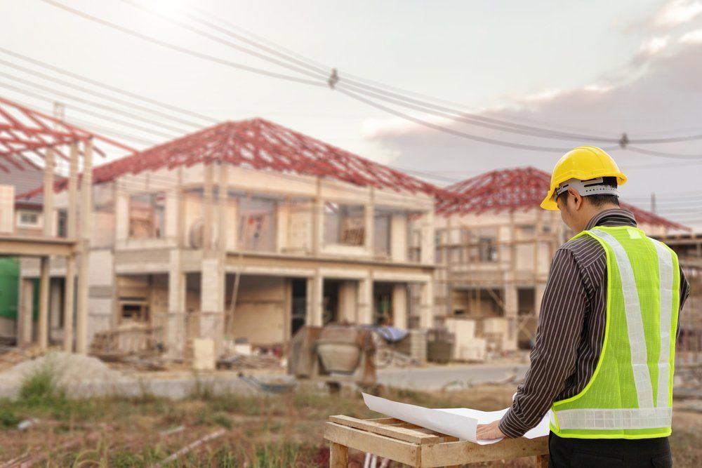 Contractor Looking Over Building Blueprints — Building Compliance in Mackay, QLD