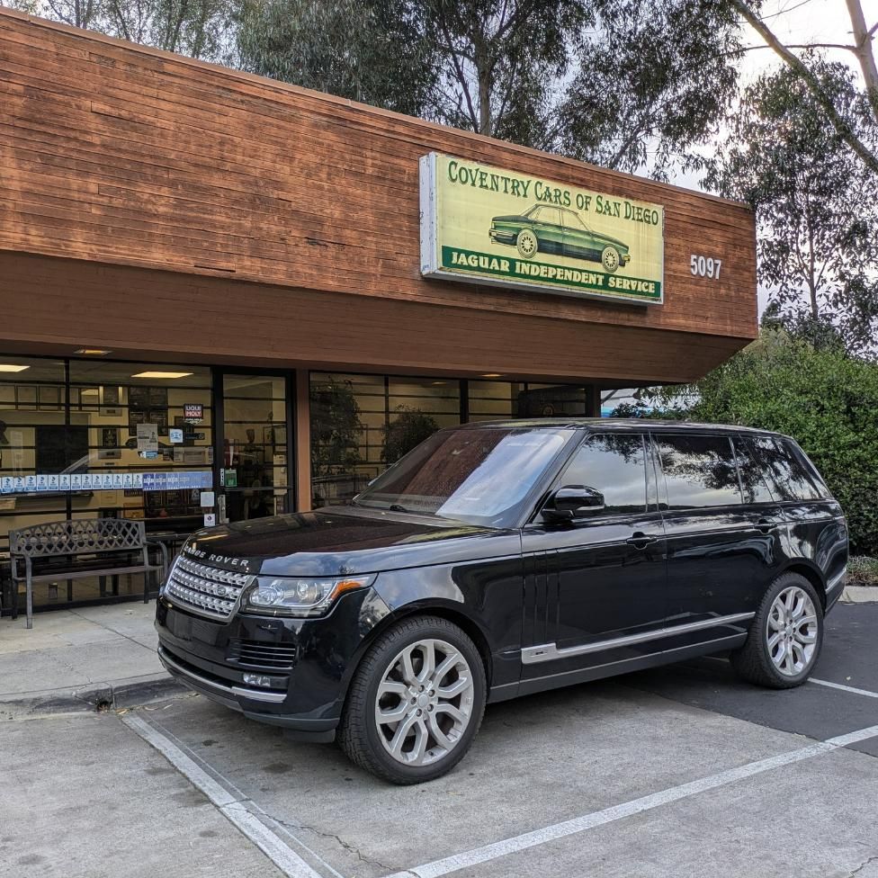 Black SUV parked outside a thrift store with a green sign and wood-paneled facade