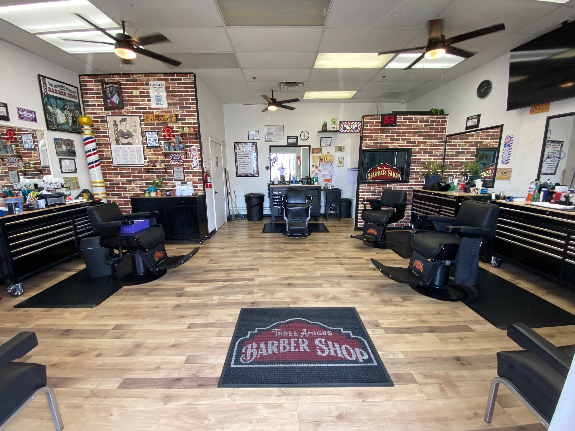 Man with a fade haircut and shaved side part in a barbershop.