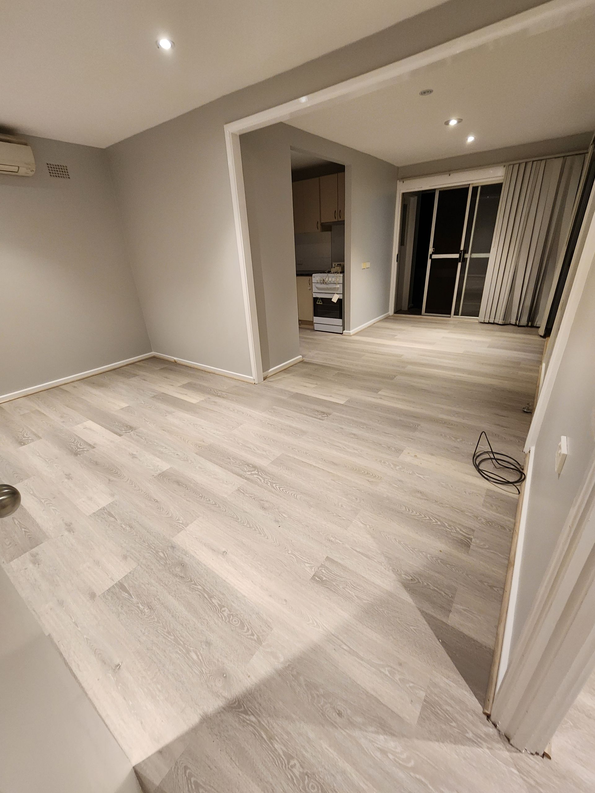 A room with hardwood floors and a sliding glass door — Nicho's Home Maintenance In Tamworth, NSW