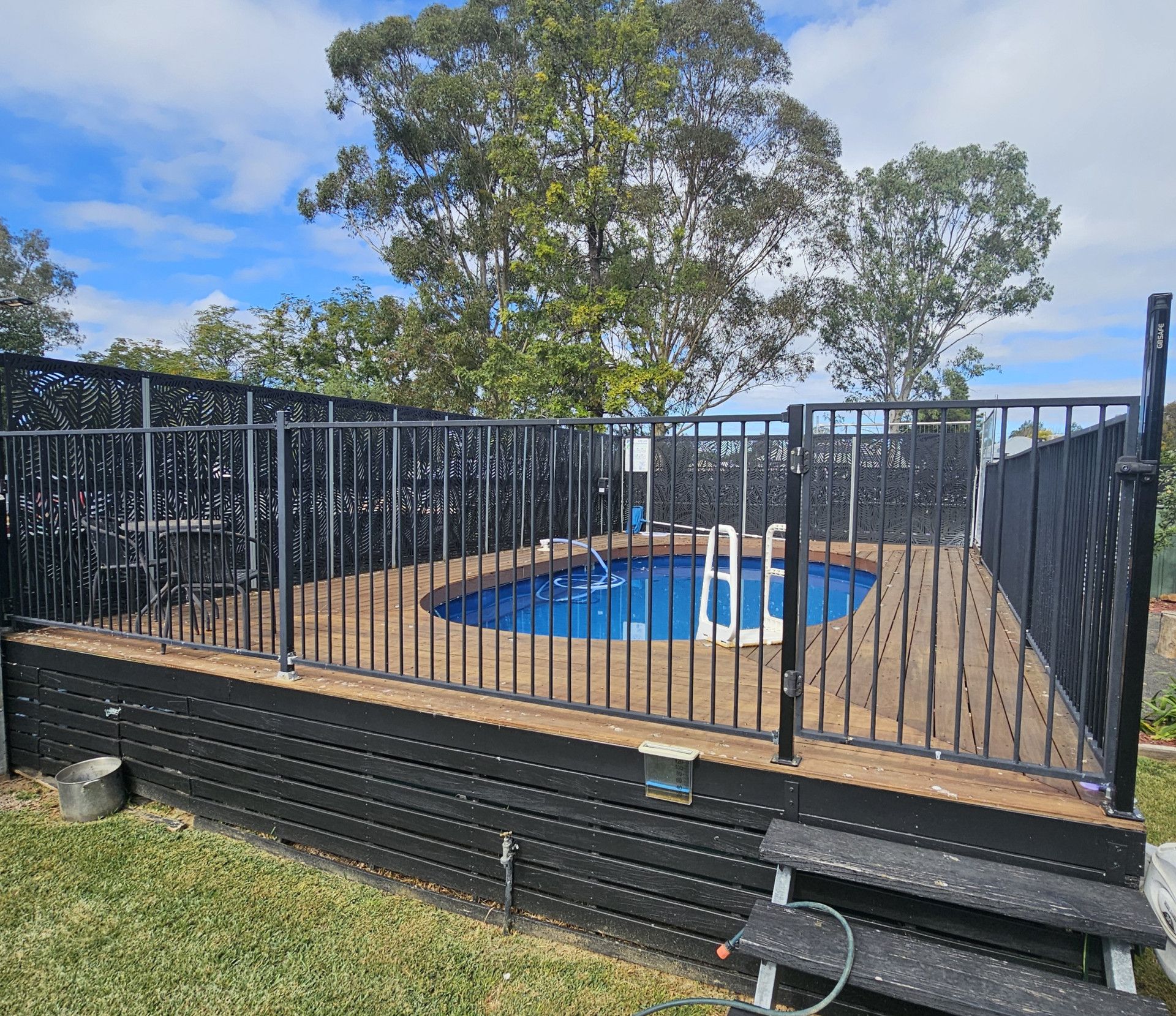 A swimming pool with a black fence around it — Nicho's Home Maintenance In Tamworth, NSW