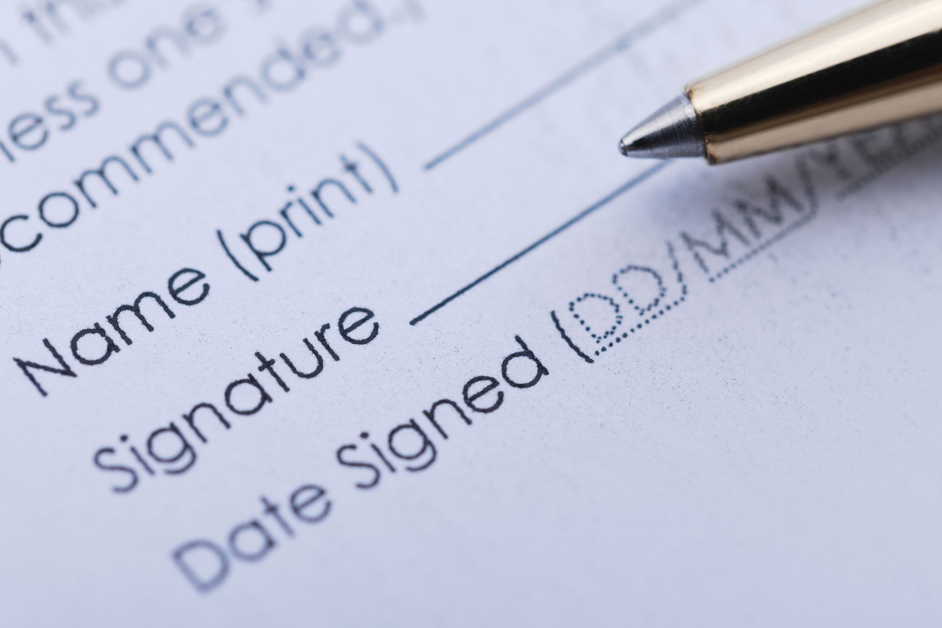 Close-up of a pen poised over a form, ready to sign. Fields for name, signature, and date are visible.