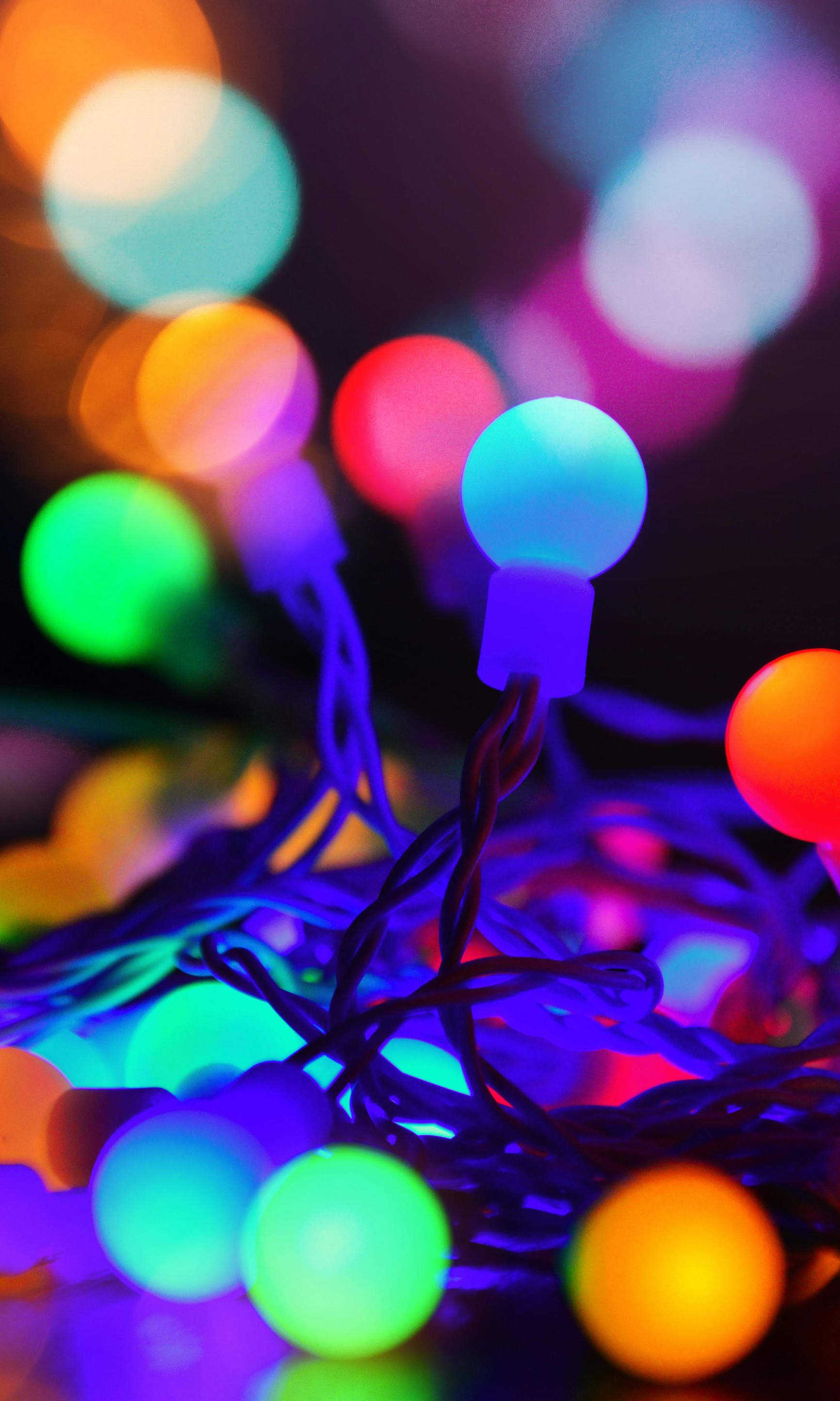 String of colorful round LED lights, with a blurred background.
