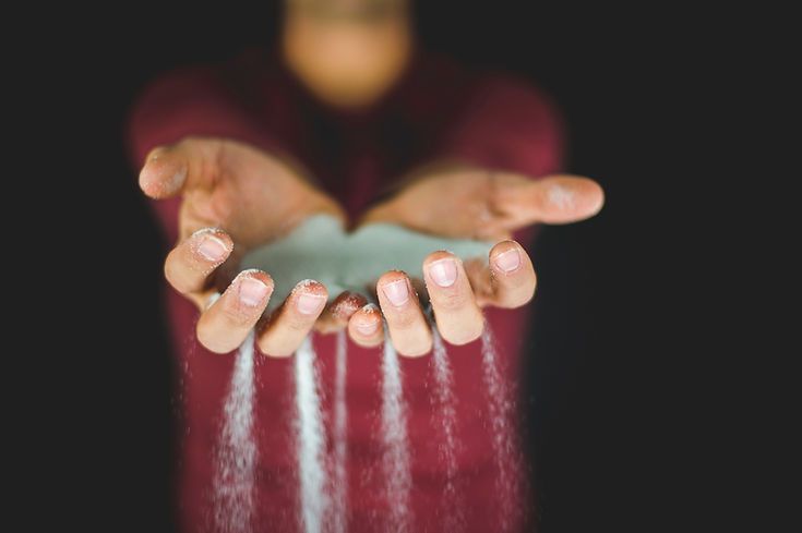 A person is holding a pile of sand in their hands.