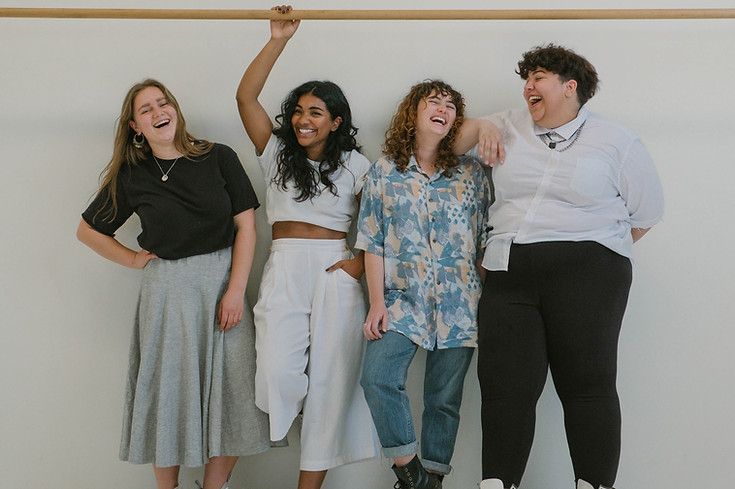 A group of women are standing next to each other and laughing.