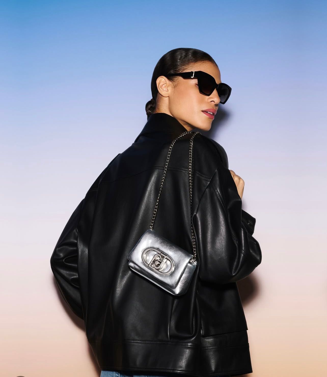 Donna con giubbotto di pelle nero e borsetta nera