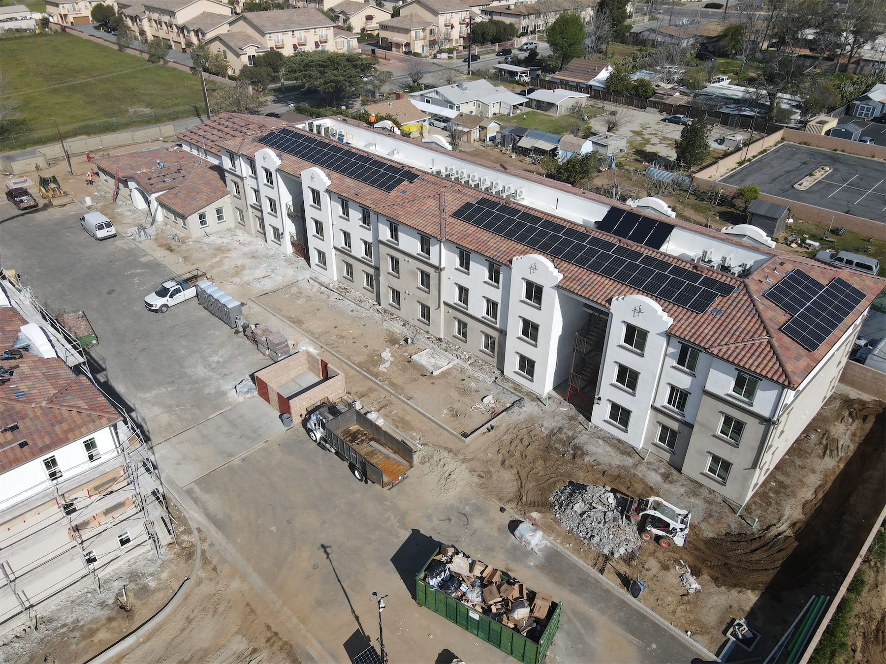 an aerial view of a building under construction with solar panels on the roof .