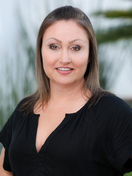 a woman in a black shirt is smiling for the camera .