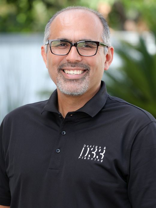 a man wearing glasses and a black shirt is smiling for the camera .