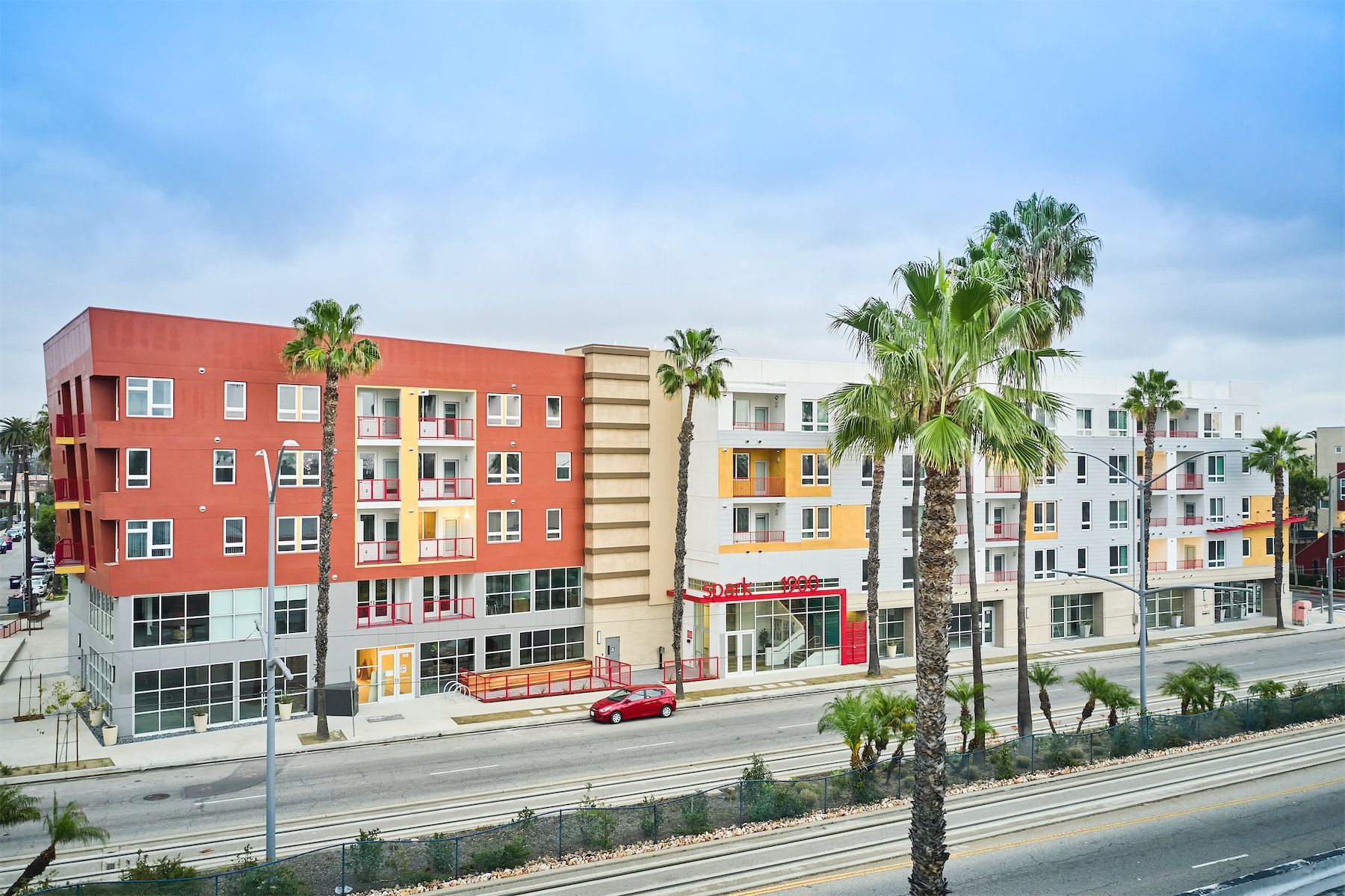a large apartment building with palm trees in front of it .