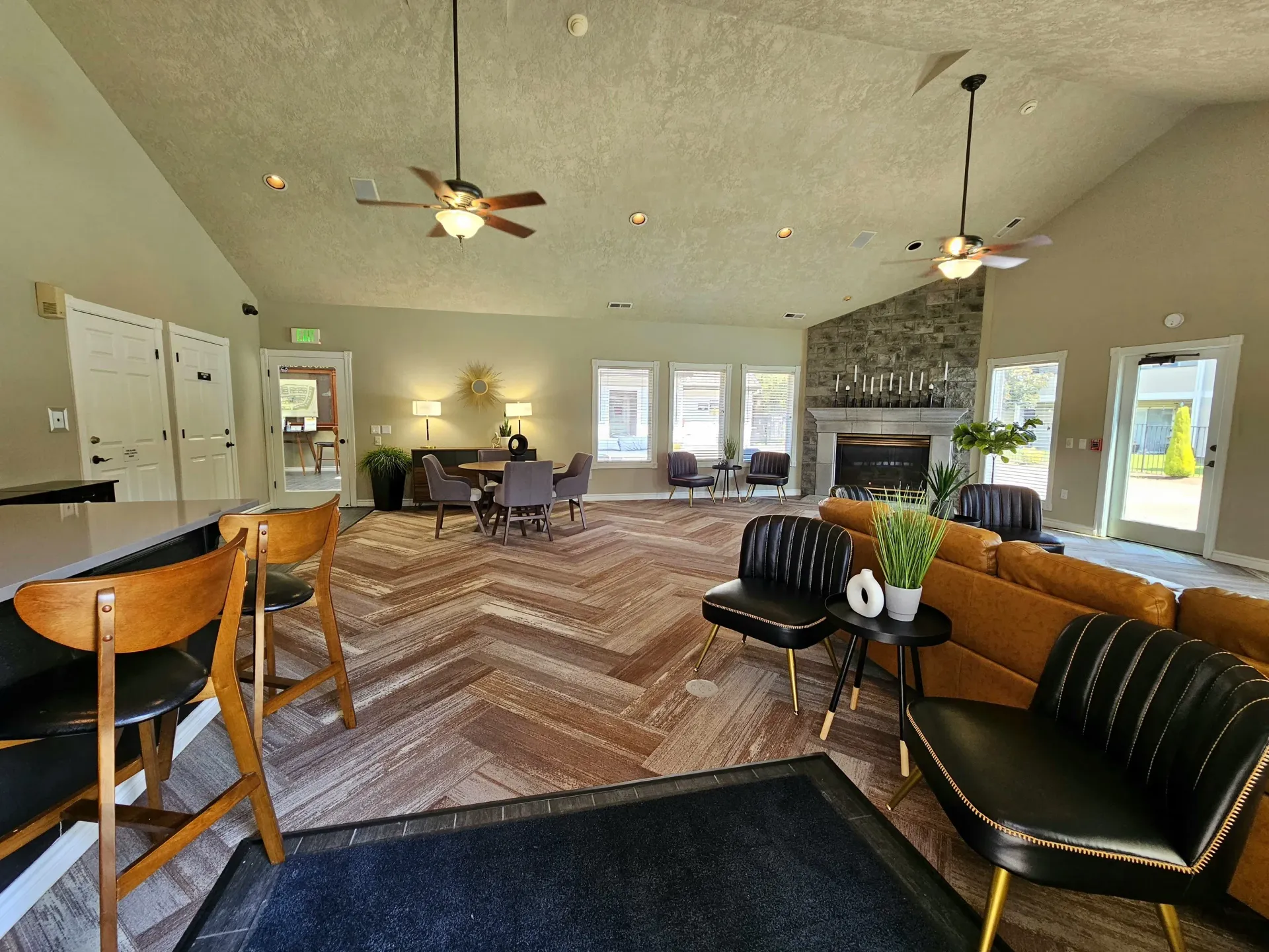 Spacious community lounge with seating, a fireplace, and large windows.