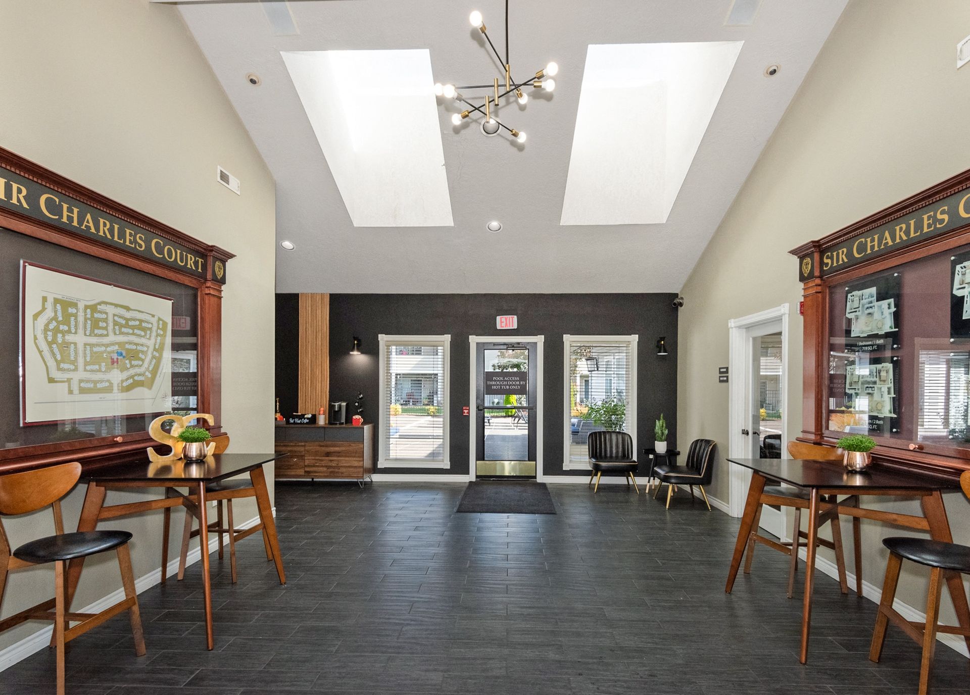 Interior lobby with two tables, chairs, reception counter, and skylights in the ceiling.