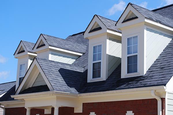 The roof of a house with a lot of windows and a blue sky in the background.