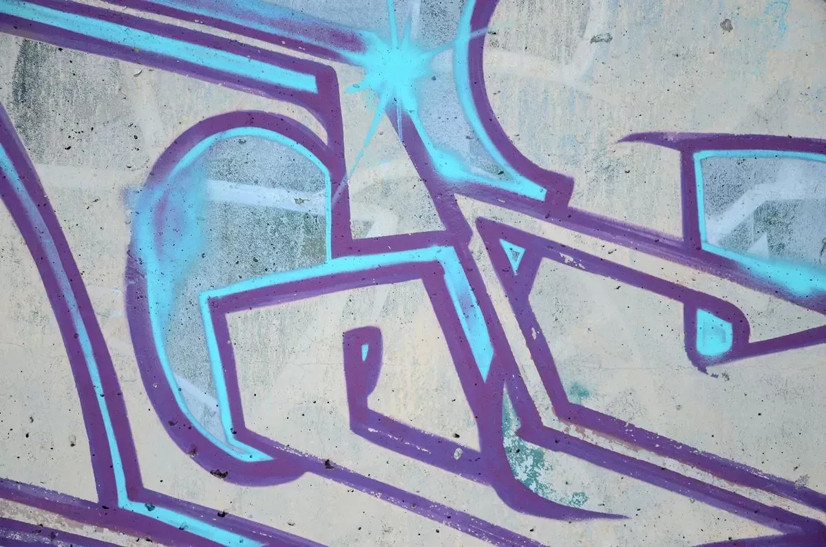 Purple and blue graffiti on a concrete wall